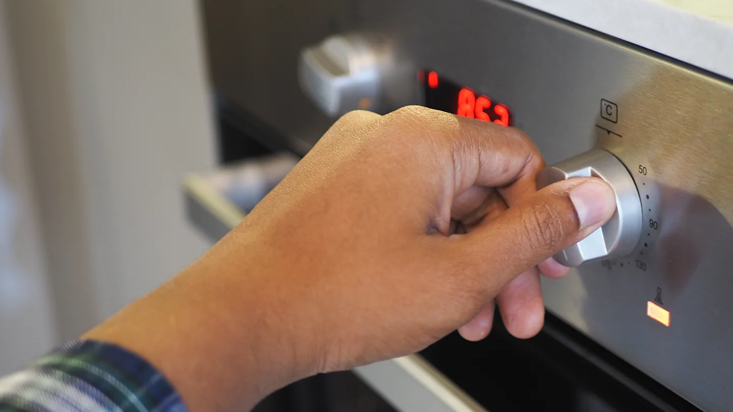 Expert Appliance Installation in Fife | Trusted Electricians in Dunfermline close up of men hand setting temperature control o 2024 12 10 05 14 02 utc